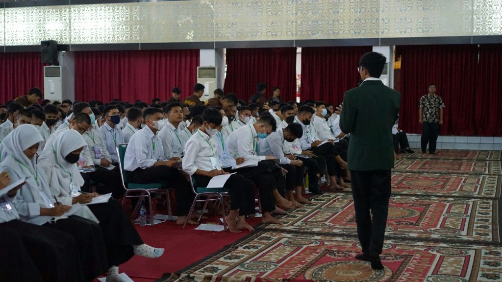 a person standing in front of a group of people sitting in chairs