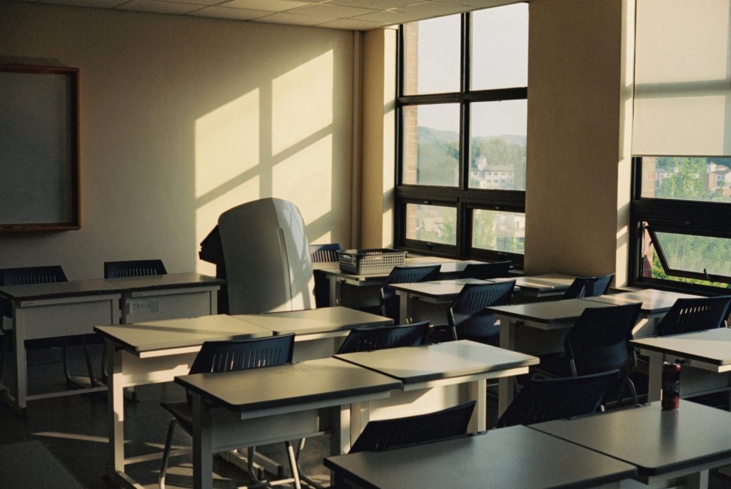 Empty classroom bathed in sunlight through the windows.